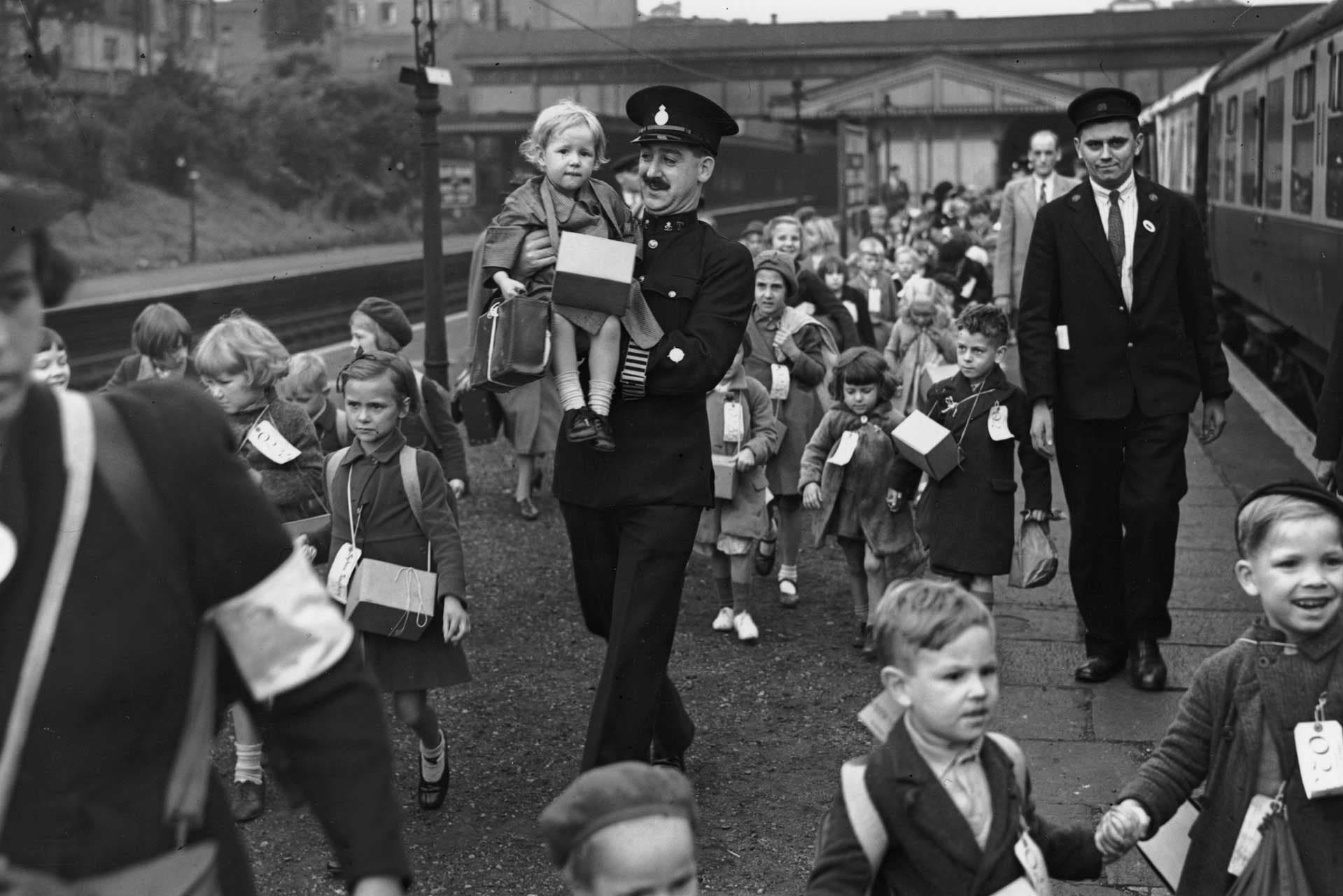 Police and railwaymen assist some of the 800 evacuee children as they leave Ealing Broadway station, London, for the country, on the first day of World War II, September 1, 1939.